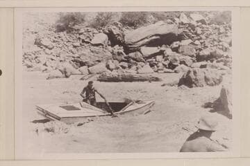 Norm Nevills in the "WEN" hung on a rock in Hance Rapid
