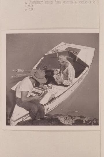 Repairing the sadiron "Joan" after damage at Rapid 23 in Cataract Canyon. Nevills wears his cap backwards and his pajama top