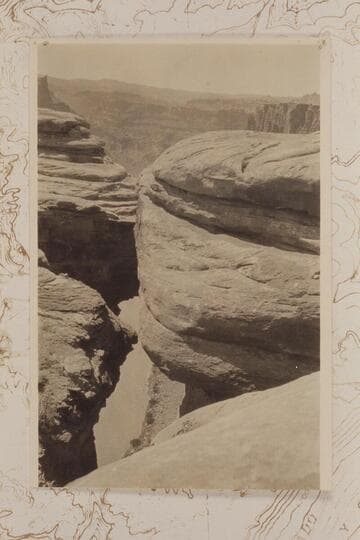 Down from the rim to the Colorado River in Cataract Canyon at approximately Mile 215.  Looking down 1200' to Colorado through crack in canyon wall near junction of Grand and Green to form the Colorado