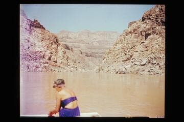 Margaret Marston riding the stern of a Nevills sadiron skiff during the 1947 cruise of the Grand Canyon