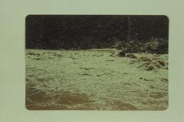 The "Esmeralda" pushing out of the lower end of Badger Rapid.  Ed Hudson is at the wheel, Marston is piloting and Taylor rides as passenger