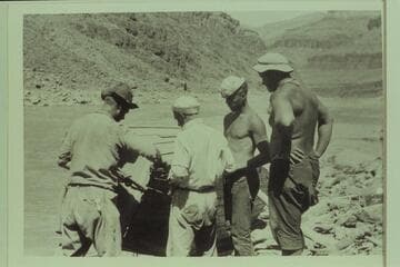 Repairs to the "Grand" after Freeman had rammed the shore in Diamond Creek Rapid. Left to right: Burchard; Kolb; Lint; and Freeman. Freeman enjoyed featuring decrepit clothing