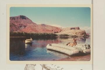 The deck boat backs into the river for a trial run.  Georgie White struggles with her boloneys at right