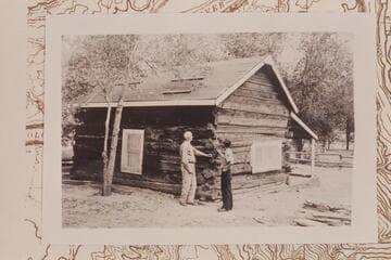 Lees Ferry Ranch cabin is examined by C. A. Griffin (owner of the ranch) and Phil Martin (park ranger).  Just behind Griffin's head is one of the heavy timbers that appeared to have been tapered for use in flotation