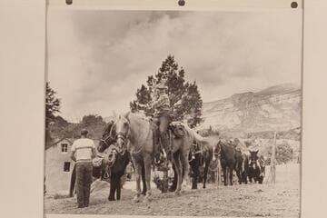 Nancy Daly leads the string out from Navajo Mountain Trading Post.  Ralph Cameron watches from left