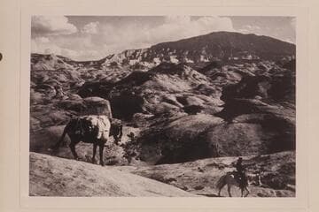 Cha Butte upper left.  Navajo Mountain from trail down from mesa west of Nasja Creek into camp near the joint.  Tobe Owl rides ahead of the pack.  The sloping mesa is 4903.  d