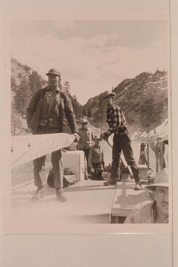 Don Smith at the forward sweep; Earl Kriley at the stern sweep.  Glen Wooldridge stands by the outboard motor well.  Keeler watches the operation