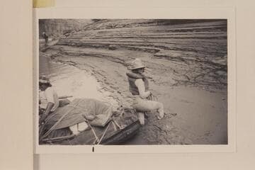 In Cataract Canyon Mile 186.5.  Caption on the back of print reads:  Kay Black leaps ashore at Mile 186.3 to 186.5 (4th camp from put-in at Potash plant on Colorado River near Moab).  Needless to say she did not expect this