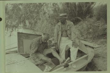 Masland and Marston study a lashing for the sound machine. The boat is the "Bootoo." Lees Ferry