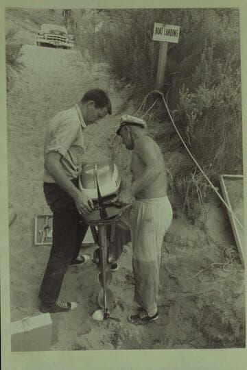 Bill Beer and Rod Sanderson nursing a motor into shape for the Grand Canyon cruise.  Lees Ferry