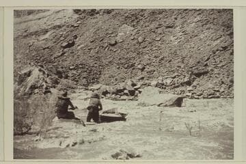 Jack Wimpress and Walt Prevost lining the 10 ft. boat down 13-Foot Rapid.  The water was so swift and rough it took constant vigilance of both men to keep the boat in control so it would not be carried out into the current to destruction