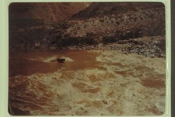 Motorboat driving into head of Lava Falls. Marston, Desloge, and Taylor in the boat