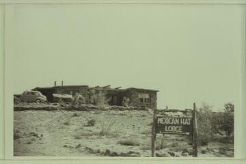 Mexican Hat Lodge.  A model of one of Norman Nevills' cataract boats is on top of the sign.  Don Wimpress's 8-ft. pram is seen on top of the trailer in front of the Lodge
