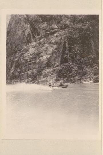 Cooper skiing on Lake Mead in Grand Canyon. One of the outboard boats nearby
