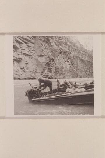 Rod works at a motor on the "Rattlesnake"; camp at Mile 157 in Grand Canyon