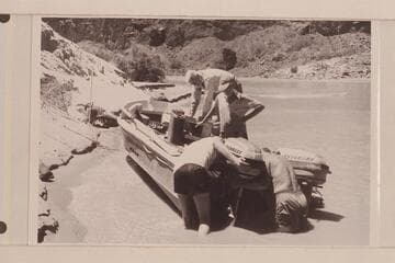 Hanging the spare motor on the "Rattlesnake" after the capsize in Vulcan Rapid. Desloge and Atherton are in the boat, Beer and Sanderson are at the stern