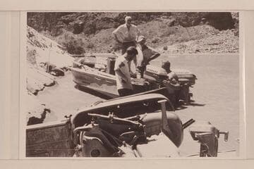Repairing the "Rattlesnake" and replacing motor after capsize in Vulcan Rapid. Desloge is standing on the boat, Atherton stands in the cockpit and Beer and Sanderson are in the water