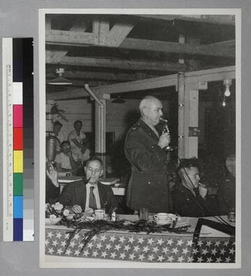 Edwin Powell Hubble seated at a party with several unidentified people