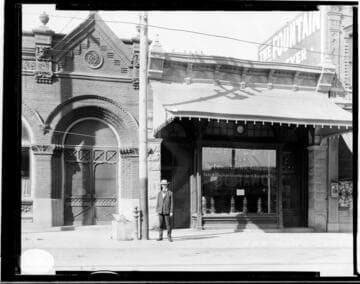 A man standing between the Santa Barbara Local Office and the Santa Barbara Consolidated Railway Office