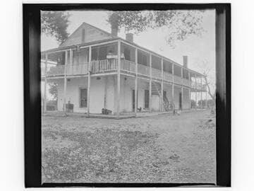 Unidentified two-story adobe building with balcony