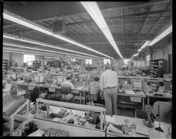 Factory with women technicians working with microscopes