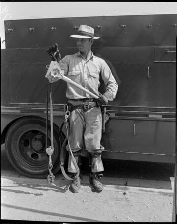 Lineman with Hi Line Hoist standing by line truck