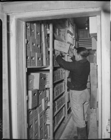 Man in cold storage locker removing a box of turkey