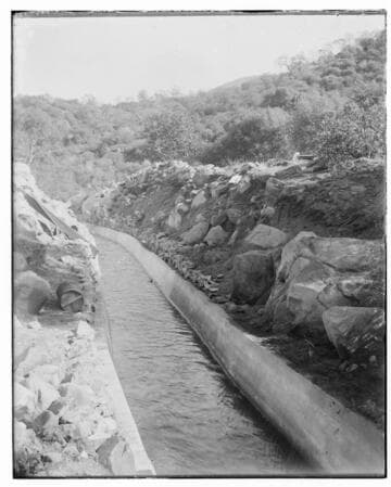 A ditch full of water at Kaweah #2 Hydro Plant.  The photo shows hills and rocks in the background