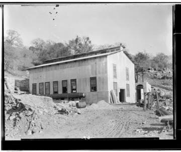 Kaweah #2 Power House under construction. The end of the pipe is next to the side of the building and construction supplies surround the area