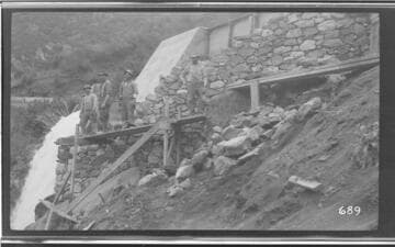 Several men repairing the ditch while the siphon spillway discharges at Kaweah #3 Hydro Plant