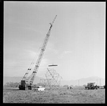 Transmission tower construction using a crane