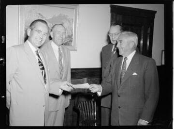 Four executives posing for check presentation