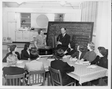 Edison Home Economists learn about a new product from a factory demonstrator in 1938