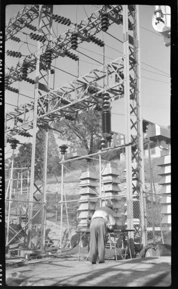Engineer running tests in switch racks at electric substation