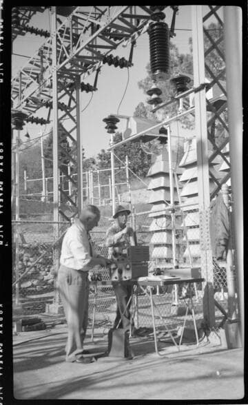 Engineers running tests in switch racks at electric substation