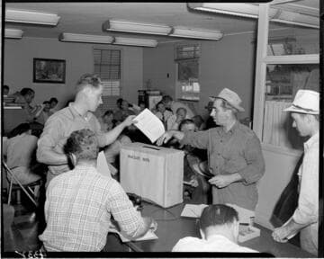 Men placing "Personnel Survey" forms into ballot box
