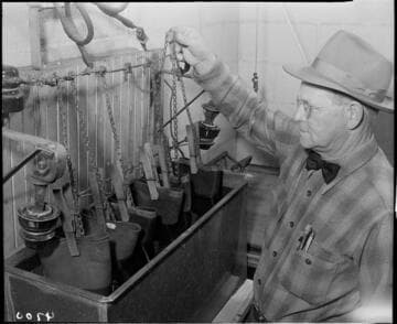 Man treating lineman's rubber gloves in tank