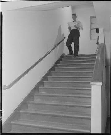man walking down stairs while reading