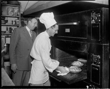 Chef taking pies out of oven