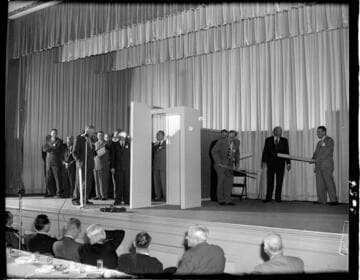 Looks like a Diamond Club initiation with blindfolded new members on stage being set up for a paddeling