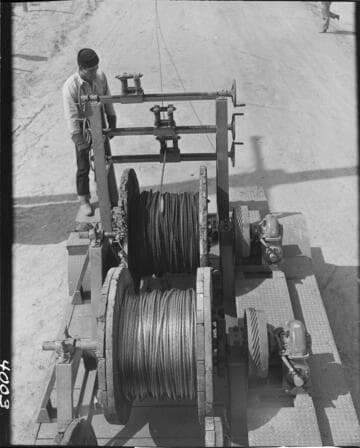 Men running conductor pulling machine