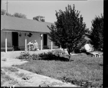 Elderly man and woman sitting on their back porch