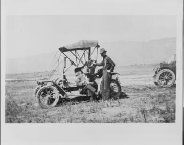 H.N. Siegfried and driver during a survey for new business, about 1915
