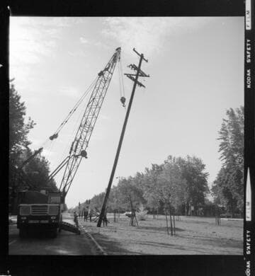 Distribution poles with cross-arms being removed (or replaced) with a crane