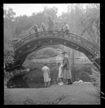 Children and adults on Japanese garden drum bridge
