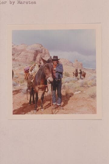 Toby Owl (Nasja Begay) prepares to unsaddle at camp in the upper end of Wilson Creek. Dan Lehi in the distance