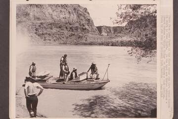 Start from Lees Ferry of the first motor run through Grand Canyon. On shore is Owen Clark and in the boat are: Bestor Robinson, Edward Hudson, Willie Taylor, Ed Hudson and Dock Marston