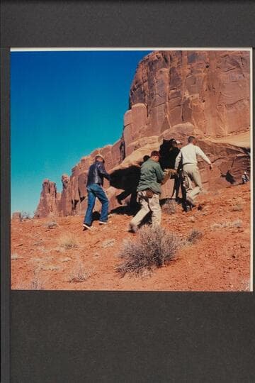 Special effects crew carrying rock to location; Park Ave., Arches National Monument