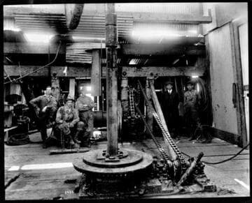 Interior oil derrick showing rotary in action of drilling
