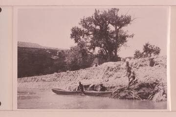 Four miles southwest of Bluff, Utah, where boats were launched 1921, July 18. Low cliff on top part of Navajo sandstone next to river. Picture taken just after launching boats